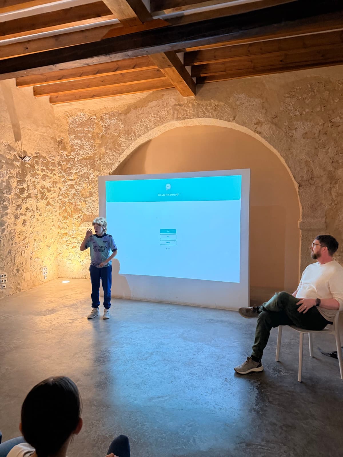 A student presenting at Torre Juana, Alicante's AI hub — view from above showing the historic stone arch