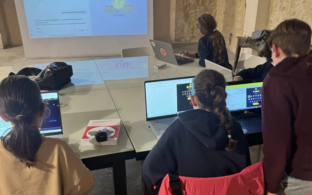 Students building their own projects on laptops in an AI Kids Club Lab, with the session projected on the wall